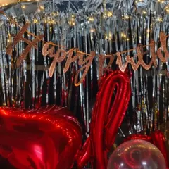 A close-up of the birthday car boot surprise, showing the "Happy Birthday" banner and the large red foil balloons that fill the space.