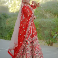 A full-length, fine-art bridal portrait showcasing the intricate details of a traditional red lehenga. I focus on classic poses and natural light to create elegant and timeless images of the bride on her special day.