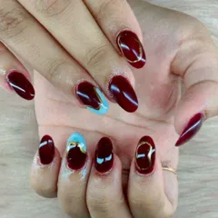 A bold and artistic design, this set combines deep maroon nails with abstract gold chrome details and a striking light blue accent nail.
