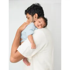 A father's gentle hold. This image captures the peaceful moment of a newborn sleeping soundly on dad's shoulder, a memory to treasure.