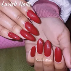 A classic and bold set of solid, glossy red nails in a chic almond shape.