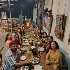 The whole tribe gathered for dinner. The long table is filled with happy faces and empty plates, a testament to the delicious food and warm company.