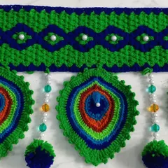 A close up of the peacock feather motif with colorful bead details, showing the intricate color work.