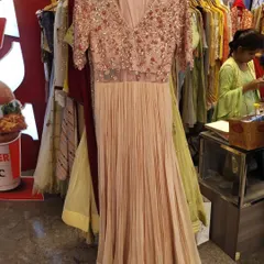 This peach gown features a beautifully embellished bodice with short sleeves and a pleated georgette skirt. It's a romantic and elegant choice for a cocktail party or an engagement ceremony.