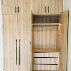 The interior of our laminate wardrobe reveals smart storage solutions, including drawers and a hanging rod with integrated lighting, all in a matching wood-grain finish.