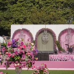 The stage for this garden event featured three large arches adorned with pink florals and crystal chandeliers. It provided a beautiful and grand backdrop for live music and performances.