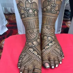 A classic and rich foot mehandi design. I've included rows of elephants, lotus flowers, and a large peacock at the ankle, covering the feet in auspicious and traditional symbols.