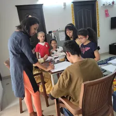 I always make sure to give each child individual attention. Here, I'm guiding a student through the initial drawing phase of our painting project, helping them build a strong foundation for their artwork.
