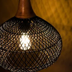 A close-up view of the lit black pendant. The light from within highlights the diamond-shaped pattern of the weave, creating a captivating visual effect against the dark finish.