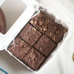 An assorted brownie box ready for Rakhi gifting. This box contains Double Chocolate, Gooey Fudgy, and Nutella Ferrero brownies, complete with a festive card.