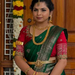 This is a classic look for a pre-wedding ritual. Nischitha looks so graceful in her green and red silk saree, with traditional gold jewelry and a soft, natural makeup look that enhances her features.