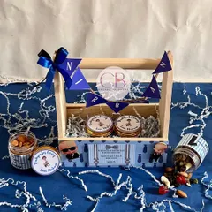 Our best-selling Boss Baby themed return favors, perfect for first birthdays. Each pinewood basket is personalized with the child's name and filled with jars of delicious treats, offering a budget-friendly yet impressive gifting option.