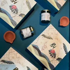 A flat-lay of our artistically designed Diwali boxes, paired with jars of chocolate-coated almonds, dry fruit mix, and traditional clay diyas.