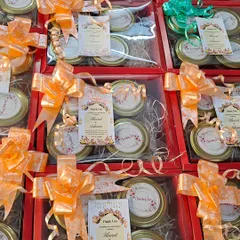Here's a look at a large order of wedding hampers. These red boxes contain four jars of treats and are finished with a personalized thank you card and a beautiful bow.
