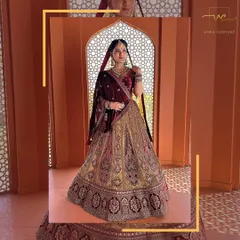 A regal pose in a magnificent multi-toned bridal lehenga. The rich velvet blouse complements the heavily embroidered skirt, creating a timeless look.