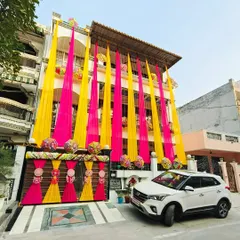 Another angle of the fully decorated house, showing how the drapes and gate decor come together to create a grand and cohesive look for a 'ghar ki shaadi'.