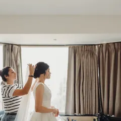 A quiet moment behind the scenes, securing the veil for a bride. A perfectly placed veil completes the look and requires a steady hand.
