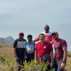 A group of colleagues on the trail to Bandaje Waterfall. The rolling green hills of the Western Ghats provide a spectacular setting for a multi-day corporate trek.