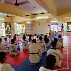 Students listen attentively as instructions are given before the belt exam begins. This is a moment of focus and preparation.