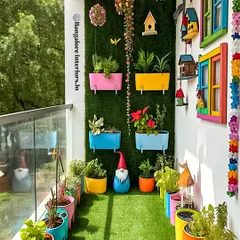 I love bringing a splash of color to a balcony to reflect a client's personality. This project uses a vibrant palette with multi-colored planters and whimsical decor against an artificial green wall. It’s a fun, high-energy design that proves small spaces can have a big impact.