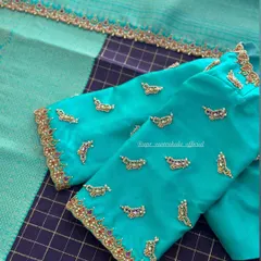 A turquoise blouse with scattered butis and an embroidered cuff.