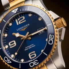 A watch par excellence! This is a detailed macro shot of a Longines timepiece, focusing on the brilliant blue dial and the contrast between the brushed steel and polished gold elements.