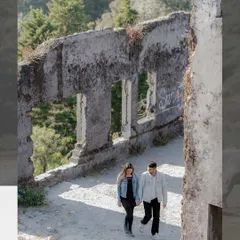 A walking shot through historic ruins nestled in the hills. This photo captures a sense of journey and exploration, with the couple moving forward together through a beautiful, textured landscape.