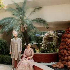 A beautiful portrait of the couple in their wedding attire. The unique decor and lush palm tree in the background add character to this lovely outdoor shot.