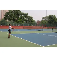 An adult player engaged in a baseline rally during a group session. We offer programs for all ages and skill levels, from beginners to advanced players.