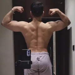 A back double biceps pose showing the muscle and definition that comes from years of heavy lifting and consistent training.