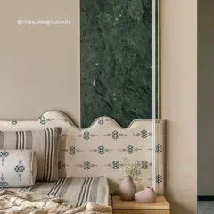 This image is a close-up of a custom headboard design where we combined different textures and materials. The patterned fabric of the headboard is set against a bold green marble panel, creating a unique and artistic statement piece.