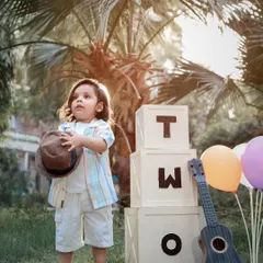 A stylish two-year-old posing during his outdoor birthday photoshoot. We capture both posed and candid moments during our toddler sessions.