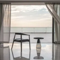A solitary chair and table are all that is needed to transform this balcony into a space for contemplation. The design of this penthouse is about creating moments of quiet connection with the vastness of the sea and sky.