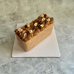This is my Hazelnut Financier Tea Cake. It's a moist cake made with hazelnut flour and topped with a light hazelnut mousse and toasted hazelnuts for a rich, nutty flavor.