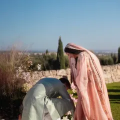 A candid moment of care between the couple during their sun-drenched ceremony in a quaint Italian villa.
