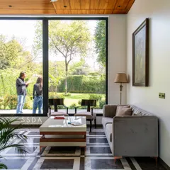 In our commercial project, The Green Axis, we designed this lounge area to feel like a calm retreat. A large, fixed glass window frames the courtyard garden like a painting, bringing the tranquility of the outdoors into a space designed for focus and conversation.
