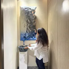 This abstract, metallic wall sculpture is a true conversation starter. Paired with a smaller sculpture on a pedestal, it creates a modern and artistic entryway. I love how it plays with light and reflection.