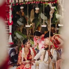 A candid moment from a traditional wedding ceremony, filled with smiles and family involvement.