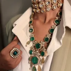 The power of two. A stunning emerald necklace is layered over a bold, uncut polki diamond choker, creating a rich texture and a look that is perfect for a cocktail party or reception.