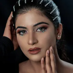 Another angle of this stunning creative makeup. The pearl hair accessories and face gems catch the light beautifully, showing the intricate detail of the work.