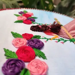A close-up of the woven wheel roses and braided hair in the embroidery hoop art. I love adding these small, detailed touches.