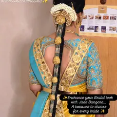 A beautiful example of a traditional South Indian bridal hairstyle, featuring a full gold-finish jada bangara that adorns the entire length of the braid.