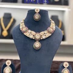 This polki necklace set with multi-coloured stones is a versatile choice for any wedding function. It comes with matching earrings and a maang tikka.