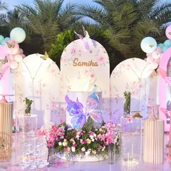 I designed this stunning butterfly-themed stage for an outdoor birthday party. The setup includes personalized floral panels, iridescent butterfly props, and a beautiful mix of fresh flowers and balloons.