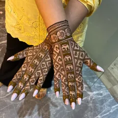 This is a very popular design featuring rows of elephants marching up the fingers. The intricate jaali (net) pattern fills the rest of the hand, creating a dense and traditional look that is perfect for brides.