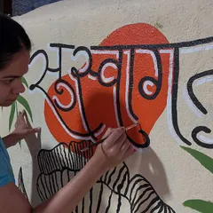 The process of creating the 'Suswagatam' mural, focusing on the precise brushwork required for the Marathi calligraphy.