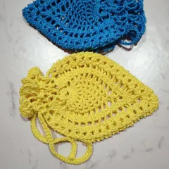 A pair of pineapple pouches in bright blue and yellow. The top of the pouch has a frilly edge that mimics the crown of a pineapple.