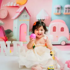 Another happy smile from the birthday girl. The detailed, custom-made background with pastel houses and cars makes these photos truly special.