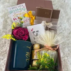 A cheerful and elegant birthday gift box for her. This hamper features a "Her" mug, a wallet, Ferrero Rocher chocolates, a scented candle, and a lovely birthday card wishing a day full of sunshine, rainbows, and love.