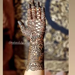 The beauty is in the details. This full-arm bridal design combines dense floral work with geometric net patterns and a beautifully detailed wrist cuff, creating a rich and textured look perfect for a bride.